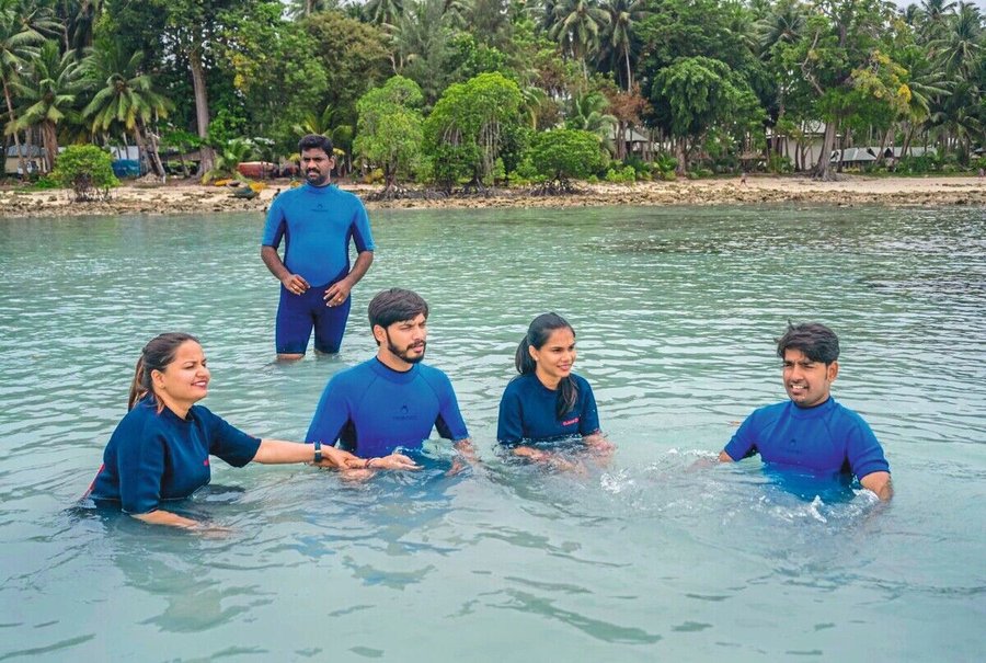 Sajan_Pulinchery,_owner_of_a_local_dive_center,_instructs_Indian_tourists_in_the_shallow_waters_off_Havelock_Island_(Swa